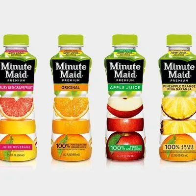 A group of four bottles of juice next to each other.