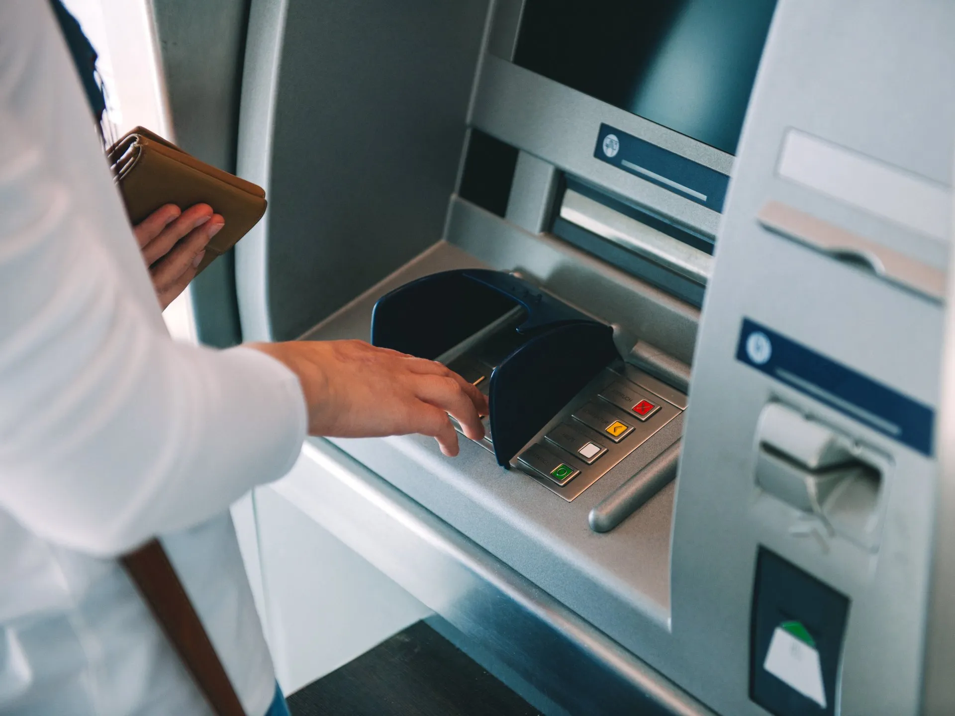 A person using an atm machine to withdraw money.